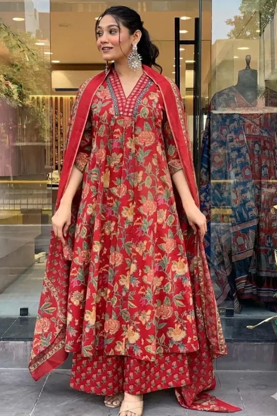 Woman wearing a red floral print A-line cotton kurti with matching palazzo pants and dupatta featuring handwork on the neckline.